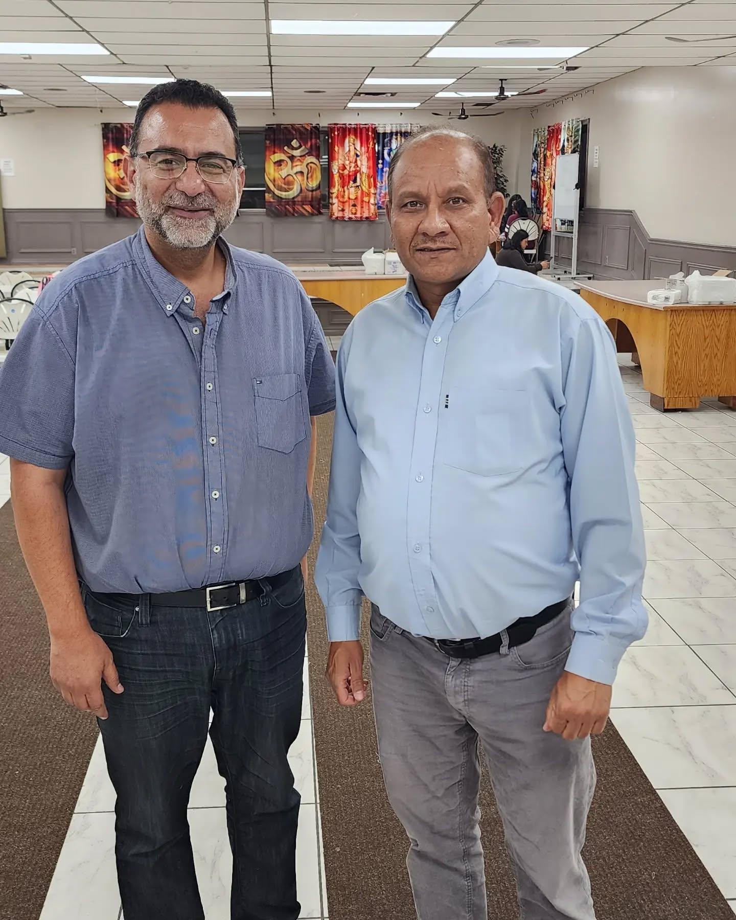 Amir Henry with a community member at a local hall